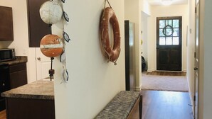 Una cocina con mostrador oscuro, un banco y una planta en maceta.