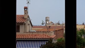 Une vue de bâtiments aux toits recouverts de tuiles rouges et d’un clocher.