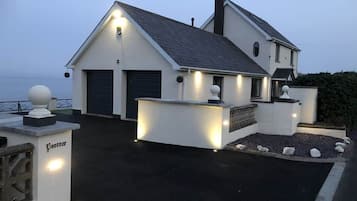 A two-story house with a garage, a driveway, and a well-lit entrance.