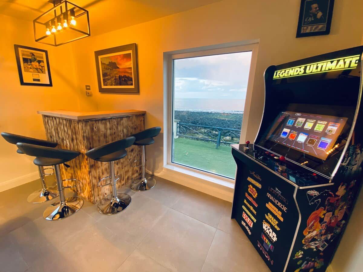 A bar area with three stools, a bar counter, and a gaming machine labeled 'LEGENDS ULTIMATE'.