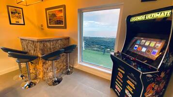 A bar area with three stools, a bar counter, and a gaming machine labeled 'LEGENDS ULTIMATE'.