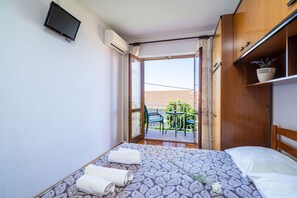 Relax in this inviting room with a large bed, flat-screen TV, and sliding glass door leading to an outdoor space.
