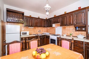 Enjoy meals in this kitchen with a dining table, microwave, stove, and refrigerator.