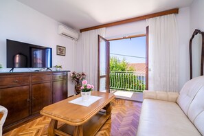 Relax in this stylish room with a comfortable sofa, flat-screen TV, and sliding glass door leading to a balcony with a view.