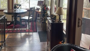 Un comedor acogedor con una mesa y sillas, un árbol de Navidad y vistas al lago.
