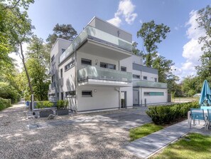 A modern multi-story building with a flat roof, large windows, and a balcony. - Tide App. 4 dike light (Ostseebad Boltenhagen)