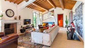 Un salón amplio con chimenea, un sofá, un televisor y una motocicleta.