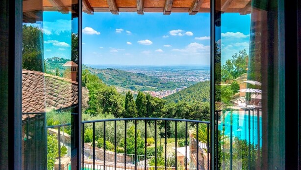 Un balcón con vistas despejadas a un valle y una ciudad lejana.