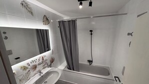 A modern bathroom with a bathtub, a sink, and a toilet. - Fewo Ideale Lage Wohn/Schlafzimmer Bad /WC Terrasse (Bad Reichenhall)