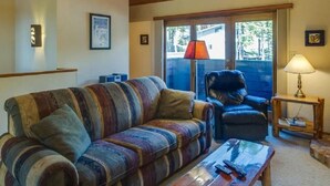 Un salon chaleureux avec un canapé à rayures, une table basse en bois et un fauteuil en cuir.