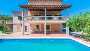 A two-story house with a pool, a balcony, and a patio area. - Villa with pool and view – Finca Can Guixe (Sóller)