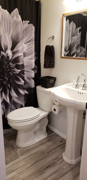 Een bad/douchecombinatie, handdoeken