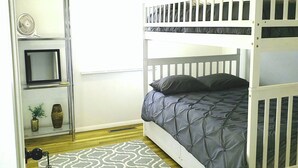 A room with a bunk bed, a small TV on a shelf, a patterned rug, and a door with a key lock. - MOTELS ARE GROSS
BEAUTIFUL RANCH STYLE
Approx 145 Nightly

DISCOUNTS AVAILABLE 
 (Columbus)