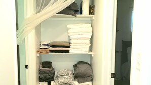 A walk-in closet with shelves for folded clothes, a basket for laundry, and a sheer curtain. - MOTELS ARE GROSS
BEAUTIFUL RANCH STYLE
Approx 145 Nightly

DISCOUNTS AVAILABLE 
 (Columbus)