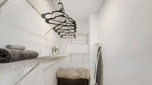 A laundry room with metal drying racks, a small storage bin, and a radiator.