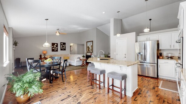 A modern kitchen with white cabinetry, a stainless steel refrigerator, and a central island with bar stools. - Hot Tub, Luxury King Bed & Yard Games ~ Quiet & Serene w Incredible Yard (Erie)