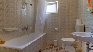 Kylpyhuone, jossa on kylpyamme, wc ja pesuallas.