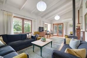 A spacious living room with a sofa set, a coffee table, and a television. - Wooshwood: Enchanting rural getaway, dogs welcome (Shadforth)
