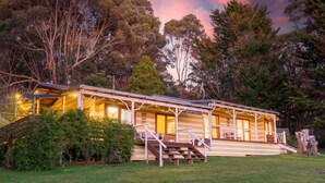 A two-story lodge with a covered porch and a staircase leading to the upper level. - Wooshwood: Enchanting rural getaway, pet friendly (Shadforth)