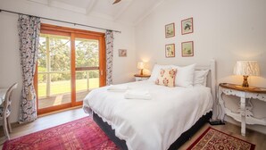 A bedroom with a bed, a ceiling fan, a window with curtains, a nightstand, a lamp, and a chair. - Wooshwood: Enchanting rural getaway, pet friendly (Shadforth)