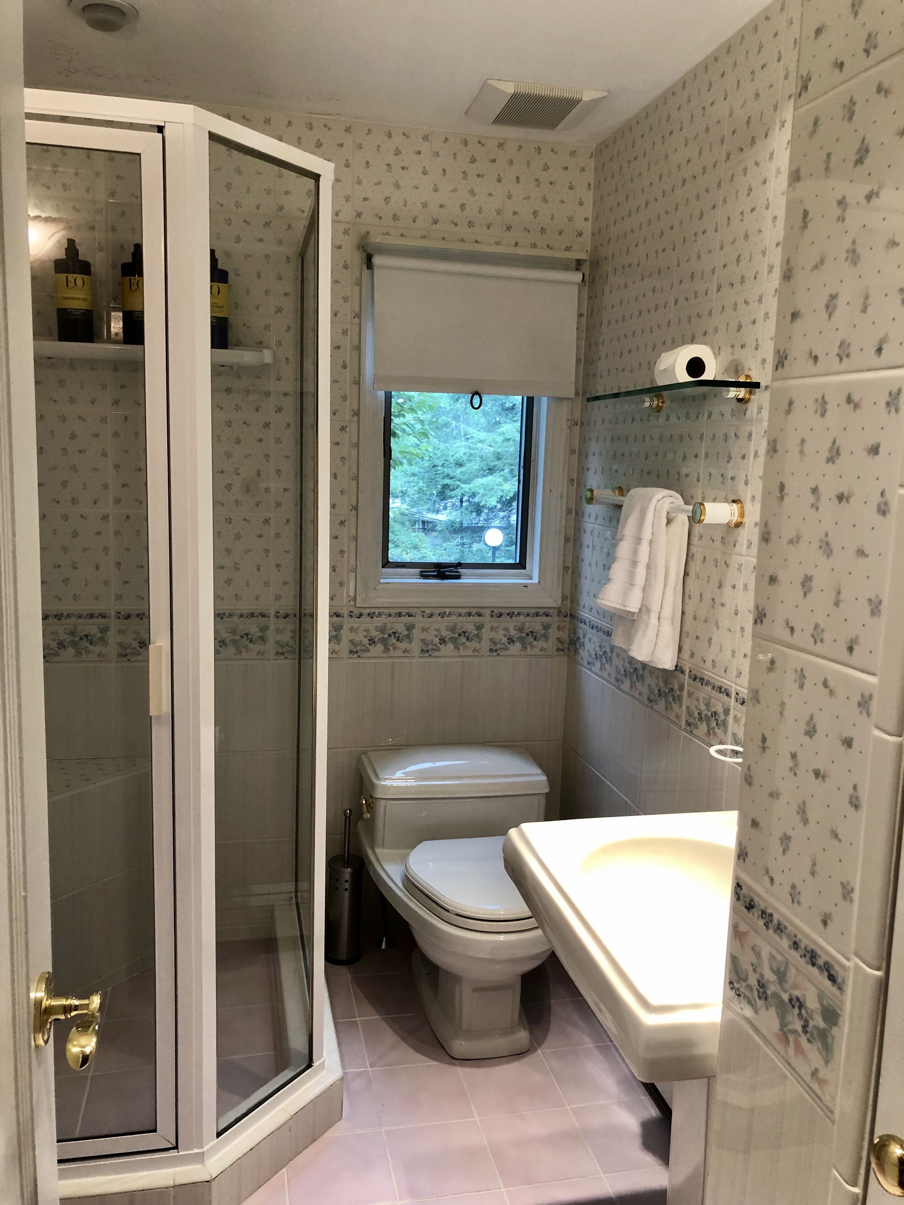 A bathroom with a shower, toilet, and sink.