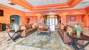 A spacious living area with a large sofa set, a coffee table, and a dining table. There is a kitchen area visible in the background. - Lakefront with Resort Amenities, 10 Mins from Disney (Kissimmee)