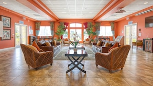 A spacious lobby with two sofas facing each other, a coffee table, and a large window with curtains. - Lakefront with Resort Amenities, 10 Mins from Disney (Kissimmee)