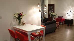 A dining area with a white table, red chairs, and a vase of flowers. - New Modern Penthouse apartment with a fantastic view (Sutton)