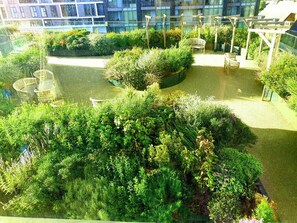 A rooftop garden with seating areas and a pergola structure. - New Modern Penthouse apartment with a fantastic view (Sutton)