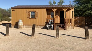 Eine Holzhütte mit Veranda, Fenster und Tür.