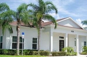 A white building with a number 3241, a wheelchair accessibility sign, and palm trees. - Lovely Townhouse in a resort located less than 10 minutes from Disney complex. (Kissimmee)