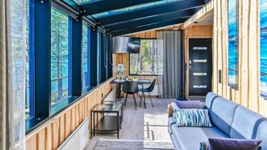 A modern cabin with large windows, a cozy seating area, and a dining space.