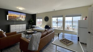 Un salon moderne avec un canapé, une table basse et un téléviseur fixé au mur.