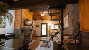 A spacious living area with a fireplace, a staircase, and a cozy seating area.