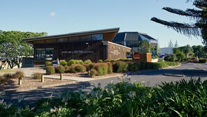 Een modern gebouw met een houten gevel en grote ramen, aangeduid als 'Estuary Arts Centre'.