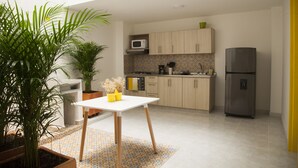 Een moderne keuken met een witte tafel, potplanten en een koelkast.