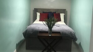 Una camera da letto con un letto, un comodino e una lampada da notte.