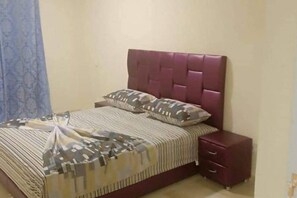 A bedroom with a bed, two pillows, a bedside table, and a nightstand. - Nice flat 6pers n ° 22 (Marrakesh)