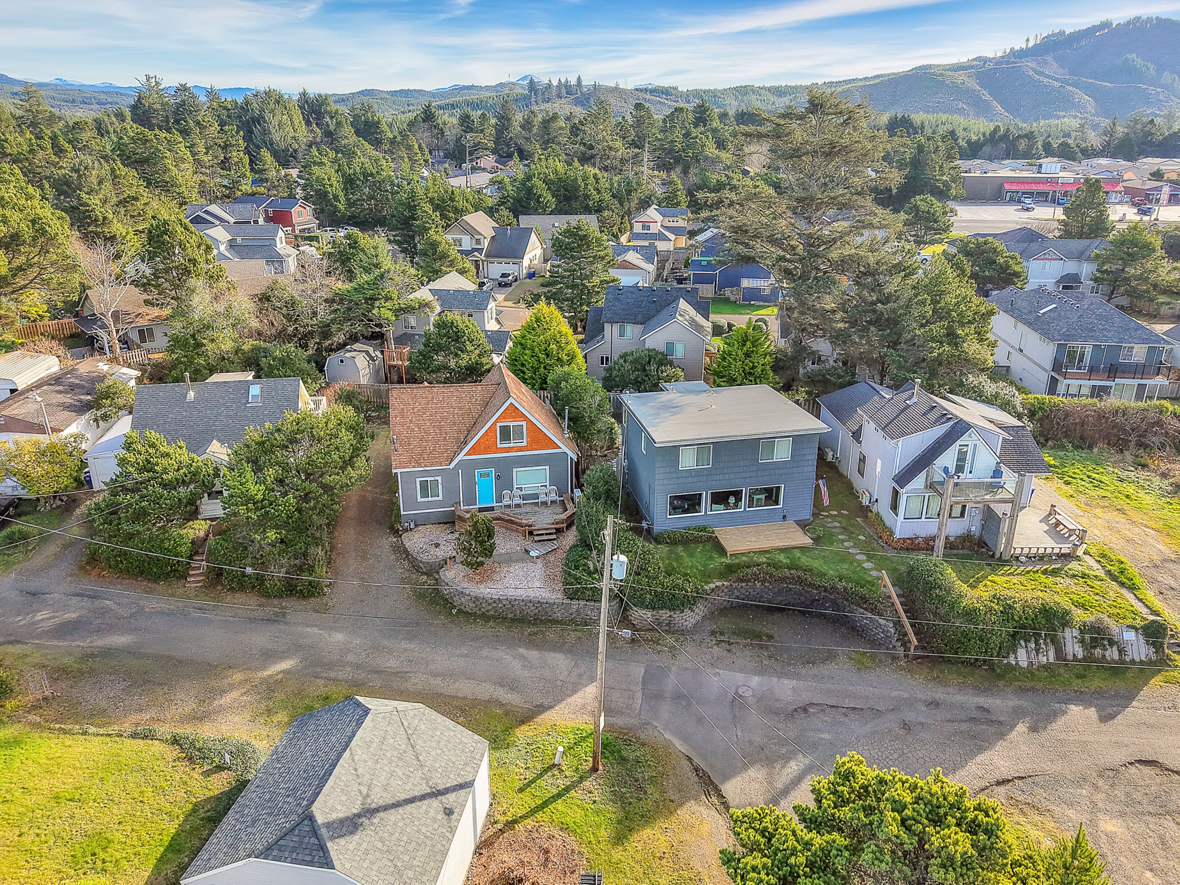 Vue aérienne d’un quartier résidentiel avec des maisons, une petite route et la végétation environnante.