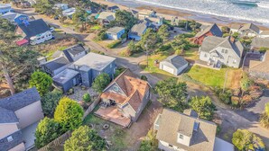 An aerial view of a coastal residential area with houses, a beach, and a clear sky. - Pet-Friendly Cottage, Walk to Beach (Depoe Bay)