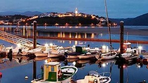 A marina with boats docked and a prominent building with a tower in the background.