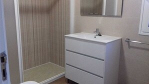 Ein Badezimmer mit Dusche, Waschbecken und Spiegel.