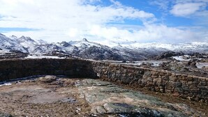 Ein Steinbau mit Blick auf schneebedeckte Berge.