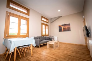 Un salon avec un canapé, une table et un tableau accroché au mur.