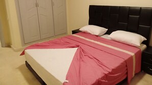 Un dormitorio con cama, mesita de noche y armario.