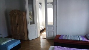 A room with two beds, a wooden wardrobe, and a door leading to another room. - Raisa Apartments PR4 (Pressbaum)