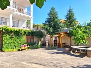 Une cour intérieure agrémentée d’une pergola, d’un espace salon extérieur et d’un bâtiment doté d’un balcon.
