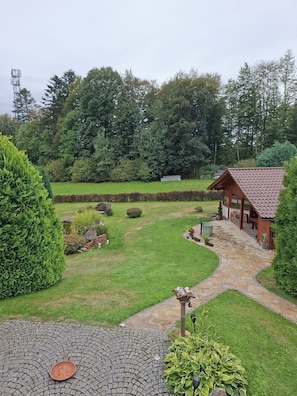 A well-maintained garden with a stone pathway leading to a wooden structure.