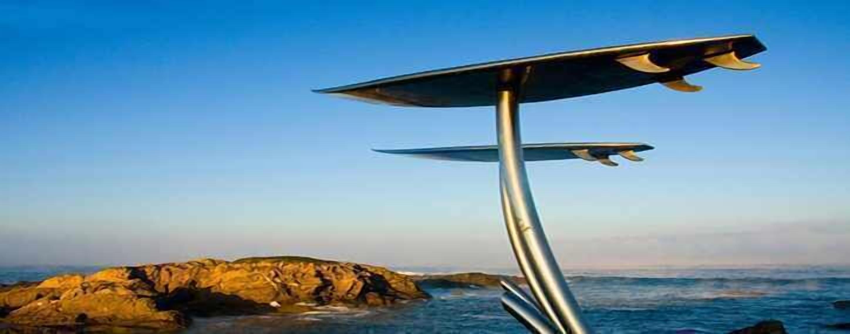 Una estructura metálica con superficie plana, posiblemente una plataforma de observación, con vistas a una costa rocosa y al océano.