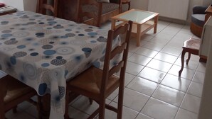 Un comedor con una mesa dispuesta para cuatro personas, un sofá de madera y una araña.